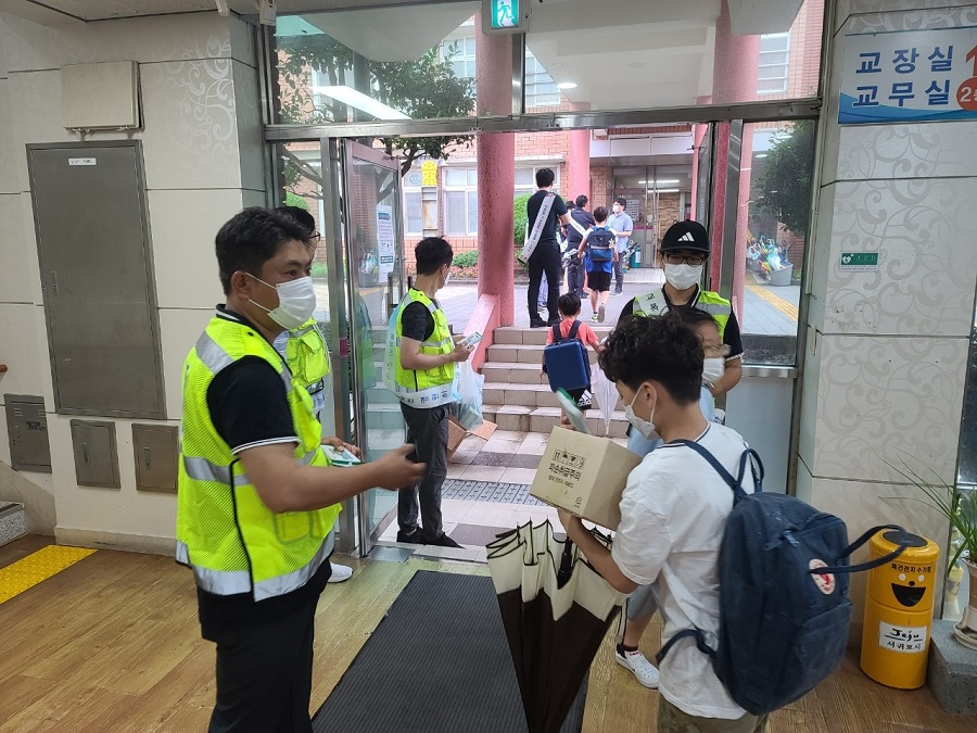 서귀포자치경찰 주민봉사대원들이 소나기가 내리는 가운데 학교폭력 예방 캠페인 홍보 활동을 하고 있다.