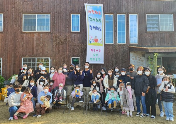 나눔장터 행사에서 요요어린이집 원아들과 가족들, 그리고 교직원들이 기념촬영을 하고 있다.